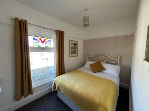 a bedroom with a bed and a window at New Derina Hotel in Blackpool