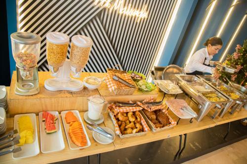 a woman standing behind a table with food on it at Hotel Estancia Chipichape Cali in Cali