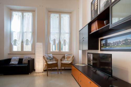 sala de estar con TV de pantalla plana y sofá en Il Borgo appartamento Clelia, en Parma