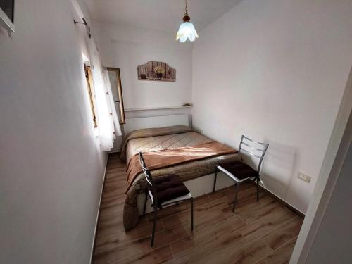 - une petite chambre avec un lit et une chaise dans l'établissement Katia's Home, à Scalea