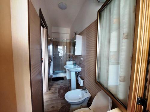 uma casa de banho com um WC, um lavatório e um espelho. em Katia's Home em Scalea