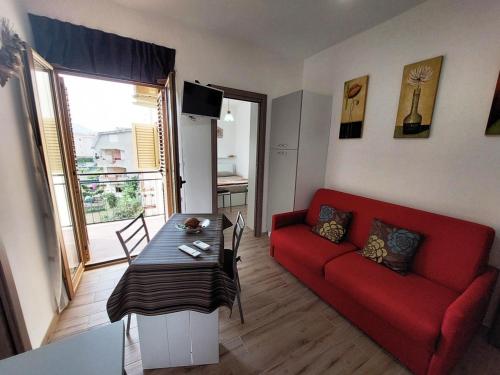 a living room with a red couch and a table at Katia's Home in Scalea