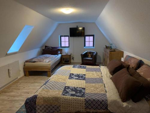 a attic room with a bed and a couch at Ferienhaus Sissi mit Whirlpool, Sauna u sehr ruhig in Großschönau