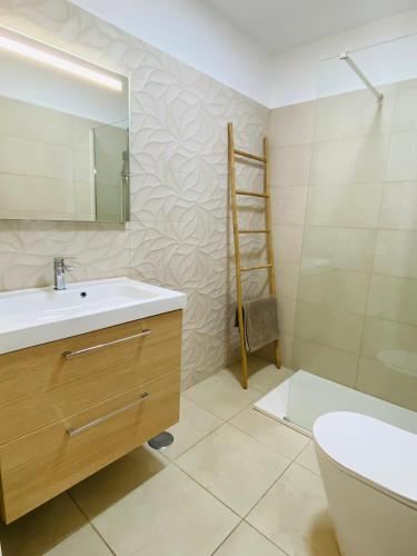 a bathroom with a sink and a toilet and a mirror at Bonito apartamento cerca del mar in Puerto de Santiago