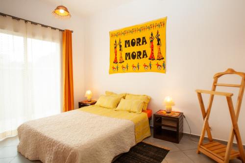 sypialnia z łóżkiem i plakatem na ścianie w obiekcie LAMINA Appart w Antananarywie
