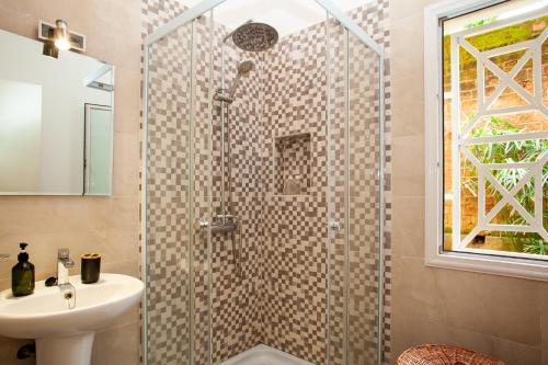 a bathroom with a shower and a sink at LAMINA Appart in Antananarivo