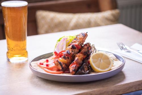 a plate of food on a table with a glass of beer at White Hart Inn in Blythburgh
