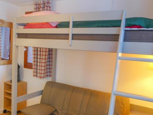 een slaapkamer met 2 stapelbedden en een stoel bij Studio Tignes, 1 pièce, 3 personnes - FR-1-502-450 in Tignes