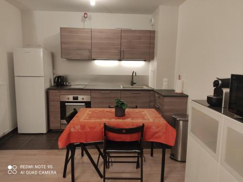 eine Küche mit einem Tisch und einem roten Tischtuch darauf in der Unterkunft Cosy Stay in Saint-Germain-en-Laye