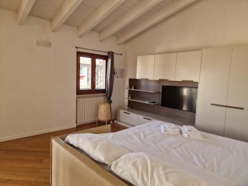 ein Schlafzimmer mit einem Bett und einem TV in der Unterkunft Vittoria al Lago in Desenzano del Garda