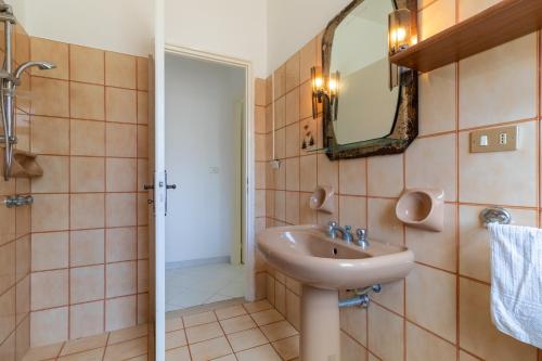 La salle de bains est pourvue d'un lavabo et d'un miroir. dans l'établissement Villetta a due passi dal mare, à Granelli