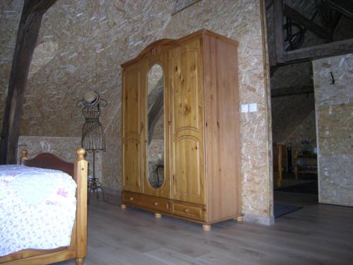 a bedroom with a wooden cabinet in a room at Gîte Onze in Liessies