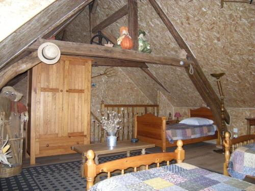 1 dormitorio con altillo con 1 cama y 1 mesa en Gîte Onze, en Liessies