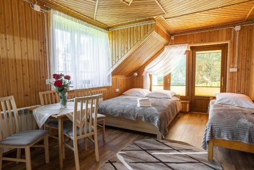 a bedroom with two beds and a table and chairs at Szarotka in Bukowina Tatrzańska