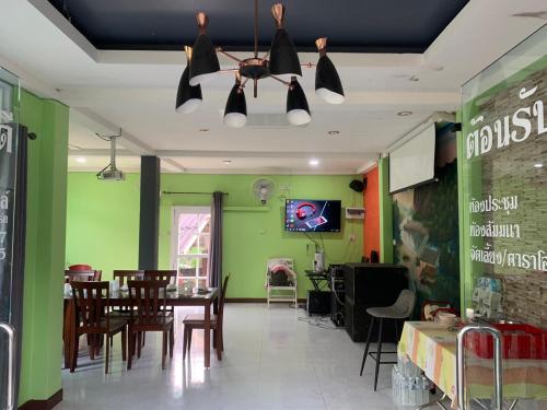 蘭沙加的住宿－ภูผาฮิลล์ รีสอร์ท，一间拥有绿色墙壁和桌椅的用餐室