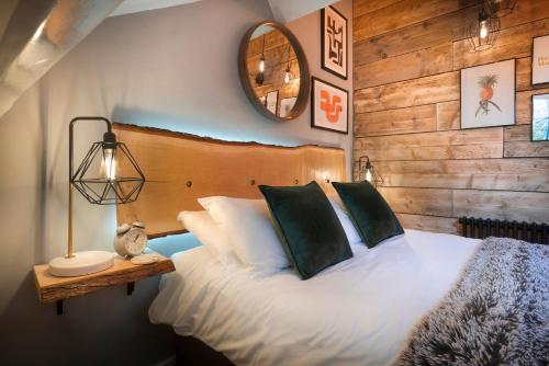 a bedroom with a bed with a wooden wall at Windermere Central Hotel - Central Lake District Hotel in Windermere in Windermere