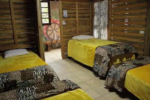 2 camas en una habitación con sábanas de guepardo en Hostal Casa Búho, en Antigua Guatemala