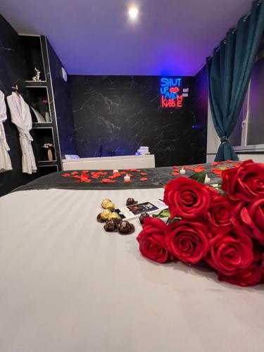 a room with red roses and a bed with a showroom at R.Suite in Saint-Étienne