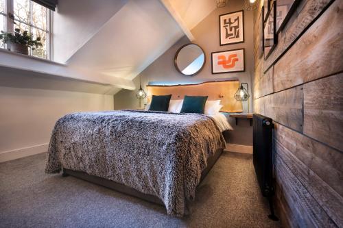 a bedroom with a large bed and a mirror at Windermere Central Hotel - Central Lake District Hotel in Windermere in Windermere
