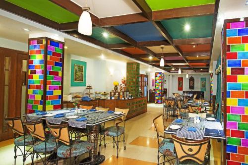 a restaurant with tables and chairs and colorful walls at Regenta Orko's Haridwar, Motichur in Haridwār
