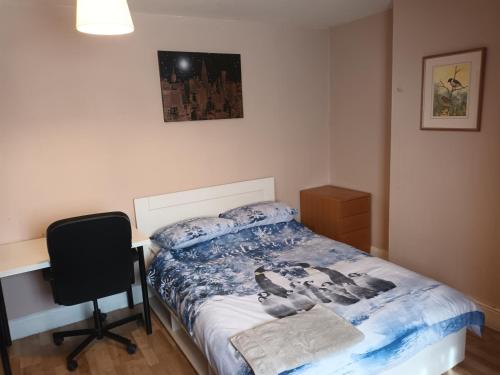 a bedroom with a bed and a desk and a chair at DACH Apartments - Cozy 3 bed Apartment in Hendon in Colindale