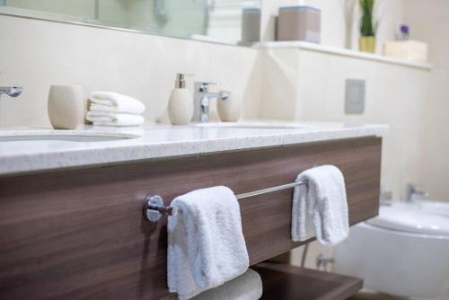 un baño con dos toallas blancas colgadas en una encimera en Superb Views & 36th Floor & Palm & Harbour View, en Dubái