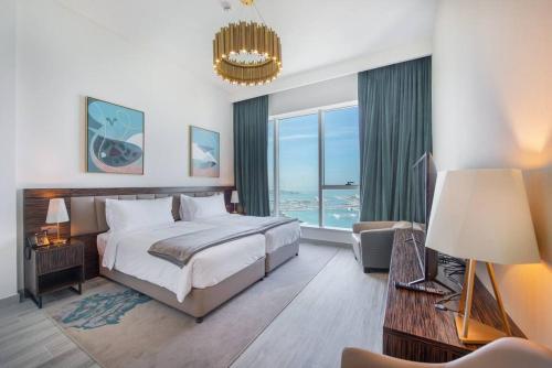 Superb Views & 36th Floor & Palm & Harbour View في دبي: غرفة نوم بسرير كبير ونافذة كبيرة