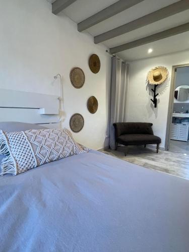 a bedroom with a bed and a chair in a room at chambres d hotes Le Mas Julien piscine chauffée adult only in Orange