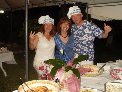 três pessoas de chapéu ao lado de uma mesa com comida em La Capanna di Giuseppe e Maria em Taormina