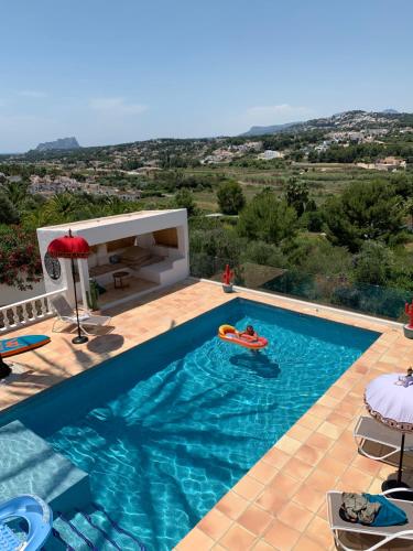 a swimming pool with a view of a villa at Moraira vue mer et montagne in Teulada