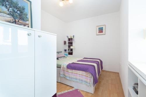 Cette chambre blanche comprend un lit et un bureau. dans l'établissement Apartment Bazen, à Zadar