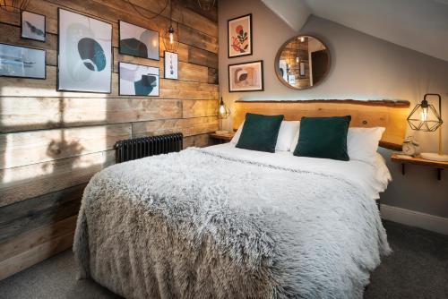 a bedroom with a large bed and wooden walls at Windermere Central Hotel - Central Lake District Hotel in Windermere in Windermere
