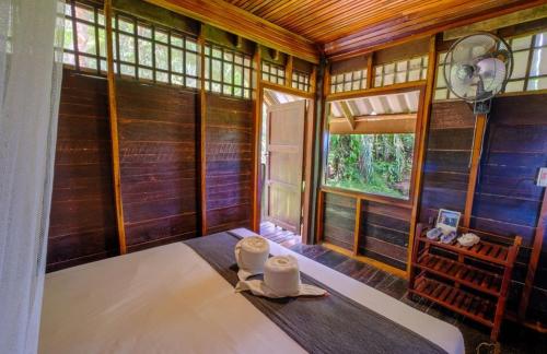 Habitación con paredes de madera y mesa con ventilador. en Khao Sok Silver Cliff Resort, en Khao Sok