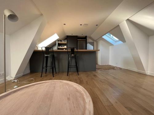 Cette chambre mansardée dispose d'un comptoir et de tabourets. dans l'établissement Sur les toits de Fontainebleau - Hypercentre, à Fontainebleau