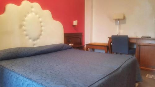 a bedroom with a bed and a desk and a desk at La Bruca Resort in Scalea
