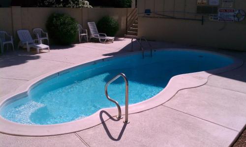 uma pequena piscina com cadeiras à volta em Colorado River Value Inn em Bullhead City