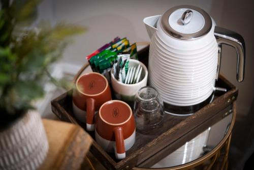 a tray with a tea pot and cups and plates at Windermere Central Hotel - Central Lake District Hotel in Windermere in Windermere
