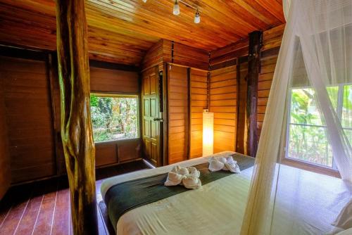 1 dormitorio con 1 cama en una habitación con paredes de madera en Khao Sok Silver Cliff Resort, en Khao Sok