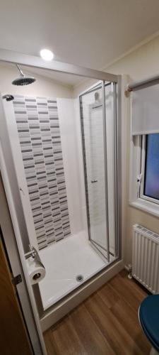 La salle de bains est pourvue d'une douche avec une porte en verre. dans l'établissement L'Exellence, à Fréjus