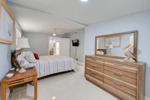 a bedroom with a bed and a dresser with a mirror at Pelican Nest, Tropical Naples Villa with Pool in Naples