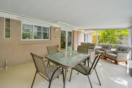 a dining room with a glass table and chairs at Pelican Nest, Tropical Naples Villa with Pool in Naples
