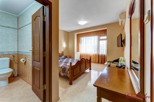 1 dormitorio con 1 cama y baño con aseo en Hotel Chuchulev, en Sozopol