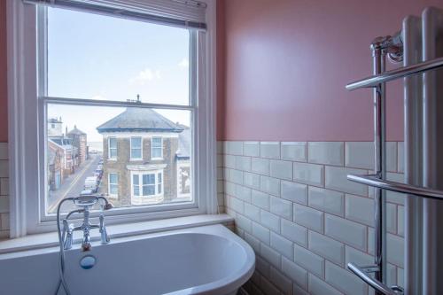 La salle de bains est pourvue d'une fenêtre, d'un lavabo et de toilettes. dans l'établissement Stunning large Victorian Maisonette with sea view, à Kent