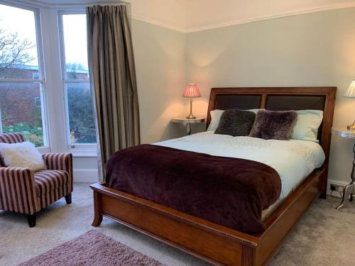 a bedroom with a bed and a chair and a window at Stunning large Victorian Maisonette with sea view in Kent