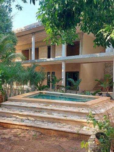 a house with a swimming pool in front of it at Kuun Beek, hotel y centro holistico in Valladolid