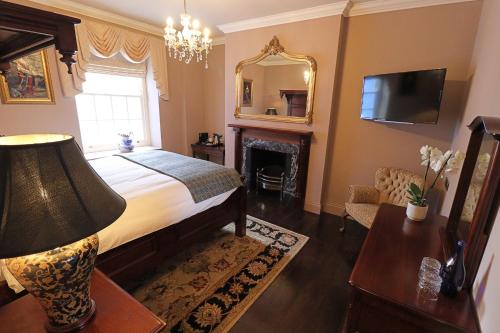 um quarto com uma cama com lareira e um espelho em The Georgian Swansea em Swansea