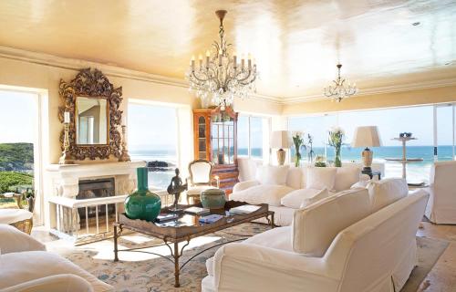 a living room with white furniture and a fireplace at Birkenhead House in Hermanus