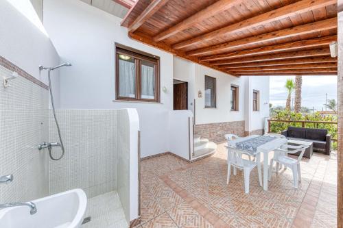 a bathroom with a shower and a table and a tub at Villetta climatizzata Mar in Torre San Giovanni Ugento