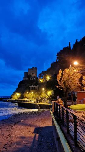 a castle on a hill next to a beach at night at La Rosa Dei Venti in Monterosso al Mare