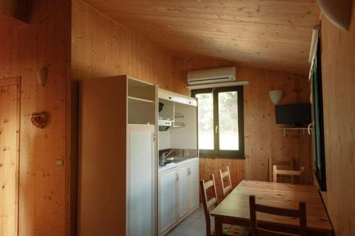uma cozinha e sala de jantar com uma mesa e um frigorífico em Valle del Lupo em San Ginesio